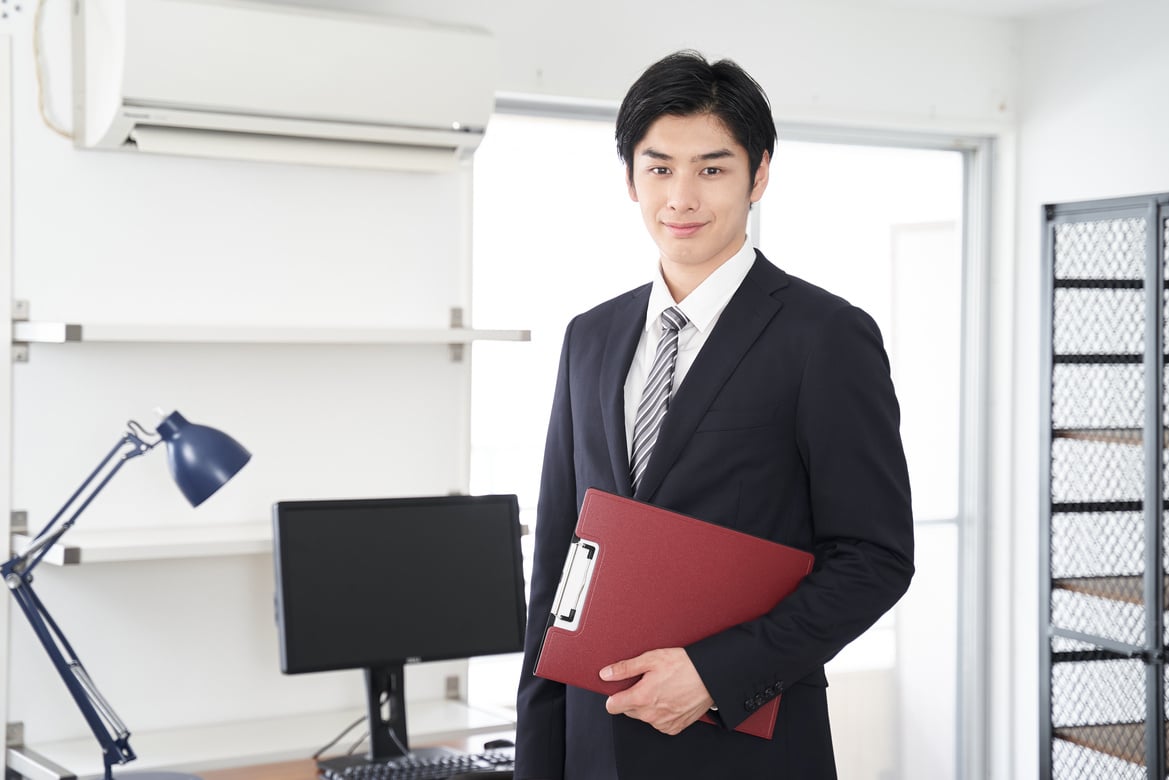 A Japanese male real estate salesman showing a house